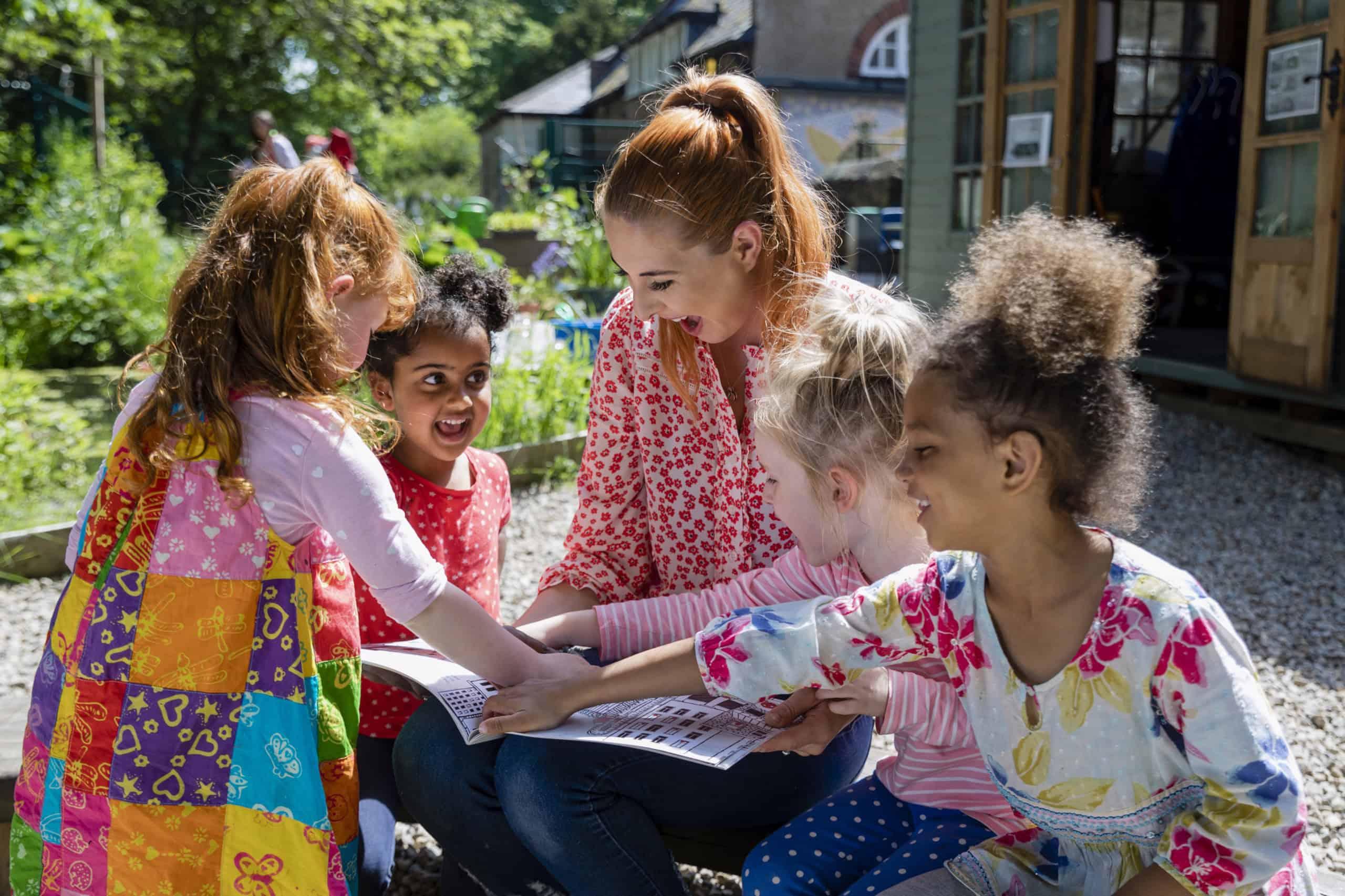 A group of young children sitting in a circle, engaging with a teacher or caregiver, emphasizing education and early child centre collaborations.