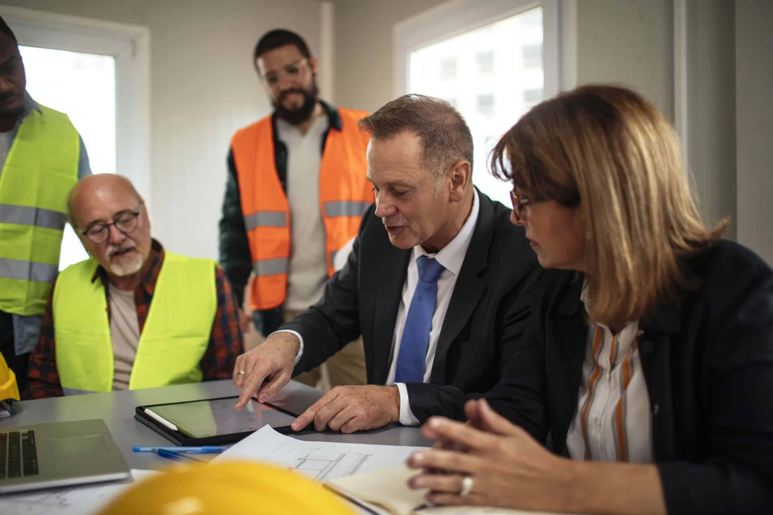 Professionals engaged in a discussion, working on a project in an office setting.