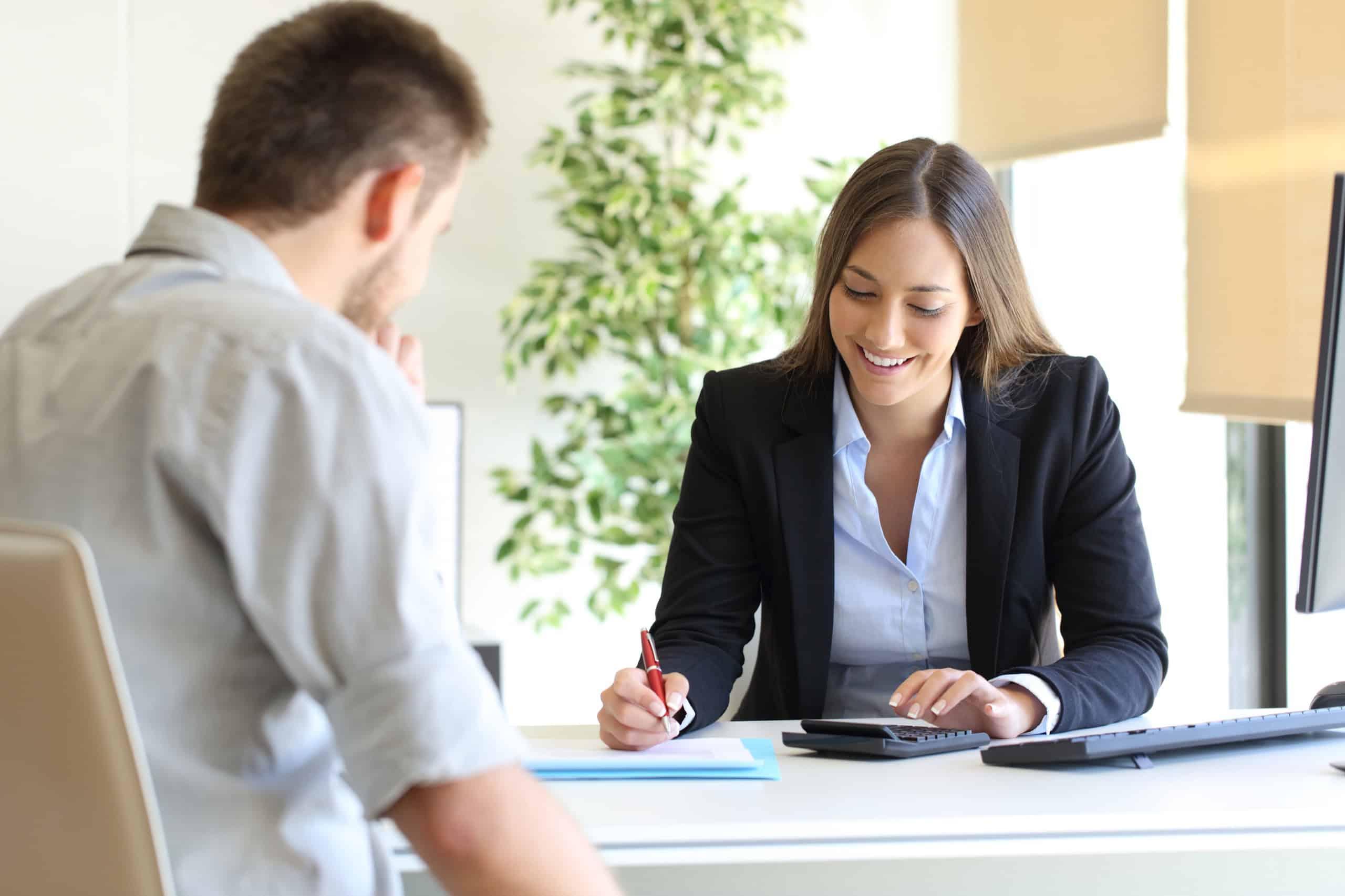 Two professionals, one in a business suit and the other seated at a desk, engaged in a discussion or support call, emphasizing responsive service.
